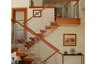 Photo of a mid-sized transitional carpeted l-shaped staircase in Seattle with open risers and wood railing.