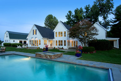 Diseño de piscinas y jacuzzis de estilo de casa de campo grandes rectangulares en patio lateral con adoquines de piedra natural