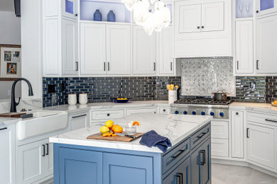 Kitchen - transitional kitchen idea in Los Angeles with shaker cabinets, blue backsplash, glass tile backsplash and an island