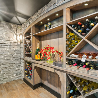 Large farmhouse walk-out basement in Cincinnati with grey walls, vinyl flooring, a standard fireplace, a stone fireplace surround and brown floors.