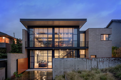 Inspiration for an industrial gray two-story glass exterior home remodel in Seattle