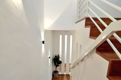 Example of a mid-sized danish wooden u-shaped metal railing staircase design in Other with wooden risers