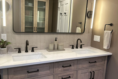 This is an example of a large master bathroom in Boston with grey cabinets, a one-piece toilet, beige tile, cement tile, beige walls, cement tiles, a drop-in sink, quartzite benchtops, brown floor, a hinged shower door, white benchtops, a double vanity, a freestanding vanity and shaker cabinets.