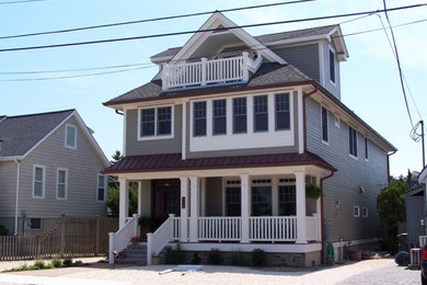 Large traditional gray three-story wood house exterior idea in Other with a hip roof and a shingle roof