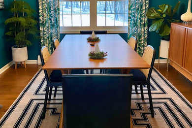Mid-sized medium tone wood floor and brown floor enclosed dining room photo in Other with green walls