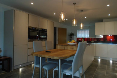 Design ideas for a large modern u-shaped eat-in kitchen in Surrey with a drop-in sink, flat-panel cabinets, grey cabinets, quartzite benchtops, multi-coloured splashback, glass sheet splashback, stainless steel appliances, vinyl floors, with island, grey floor and grey benchtop.