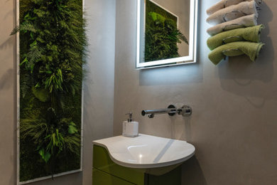 Kleine Moderne Gästetoilette mit flächenbündigen Schrankfronten, grünen Schränken, Wandtoilette, beiger Wandfarbe, Mineralwerkstoff-Waschtisch, grauem Boden, weißer Waschtischplatte, eingebautem Waschtisch und integriertem Waschbecken in München