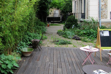 Idée de décoration pour un jardin sur cour style shabby chic de taille moyenne avec une exposition partiellement ombragée et une terrasse en bois.