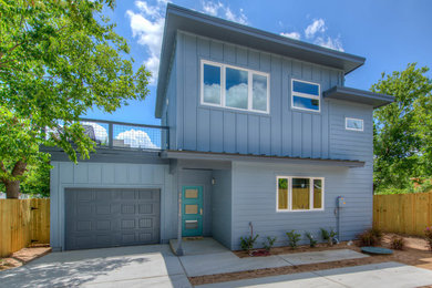 Inspiration for a large modern blue two-story concrete fiberboard apartment exterior remodel in Austin with a shed roof and a shingle roof