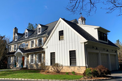 Large contemporary multicolored three-story stone and clapboard house exterior idea in Other with a gray roof