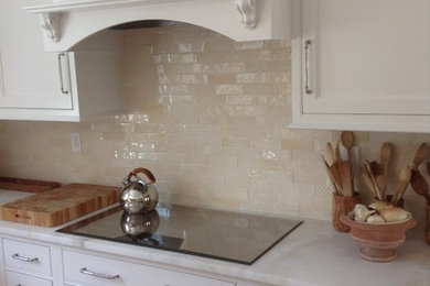 Example of a large transitional l-shaped open concept kitchen design in New York with shaker cabinets, white cabinets, granite countertops, beige backsplash, ceramic backsplash and black appliances