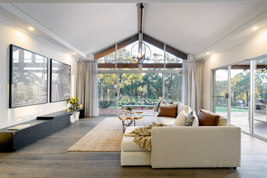 This is an example of a contemporary formal enclosed living room in Perth with white walls, medium hardwood floors and brown floor.