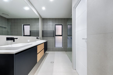 Photo of a contemporary bathroom in Sunshine Coast with flat-panel cabinets, black cabinets, black and white tile, cement tile, engineered quartz benchtops, white benchtops and a floating vanity.