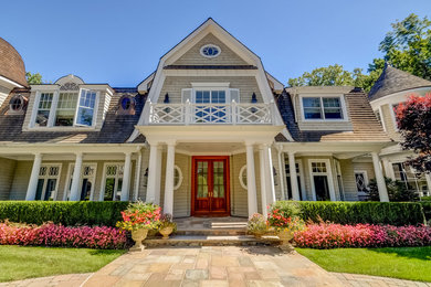 Elegant beige two-story wood house exterior photo in New York with a gambrel roof and a shingle roof