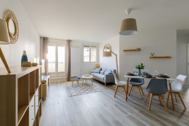 Diseño de sala de estar blanca y abierta escandinava grande sin chimenea con paredes blancas, suelo de madera clara, suelo marrón y televisor independiente