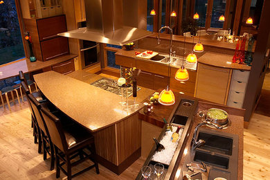 Mid-sized transitional u-shaped light wood floor eat-in kitchen photo in Other with an undermount sink, flat-panel cabinets, medium tone wood cabinets, granite countertops, stone tile backsplash, stainless steel appliances and an island
