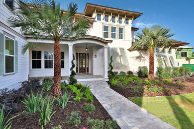 This is an example of a large beach style two-storey beige house exterior in Jacksonville with concrete fiberboard siding and a shingle roof.