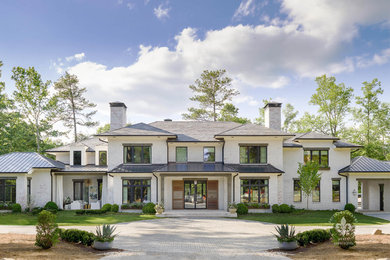 Example of a huge transitional white three-story brick house exterior design in Atlanta with a hip roof and a mixed material roof