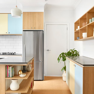 Стильный дизайн: большая параллельная кухня в скандинавском стиле с кладовкой, накладной раковиной, фасадами с декоративным кантом, фасадами цвета дерева среднего тона, столешницей из бетона, белым фартуком, фартуком из плитки кабанчик, техникой из нержавеющей стали, пробковым полом и островом - последний тренд