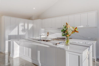 Design ideas for a contemporary eat-in kitchen in Sydney with a double-bowl sink, quartz benchtops, white splashback, stone slab splashback and stainless steel appliances.