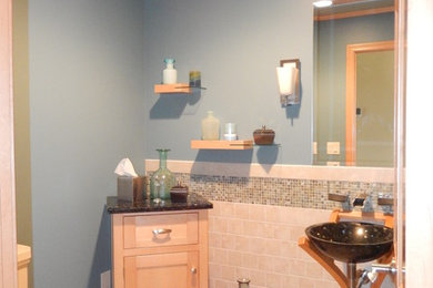 This is an example of a mid-sized contemporary powder room in Other with shaker cabinets, a two-piece toilet, gray tile, ceramic tile, blue walls, ceramic floors, a vessel sink, granite benchtops and grey floor.