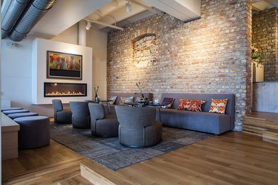 Inspiration for a large contemporary loft-style living room in San Francisco with a music area, multi-coloured walls, medium hardwood floors, a hanging fireplace, a plaster fireplace surround, a concealed tv and brown floor.