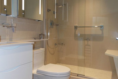 Inspiration for a mid-sized contemporary master beige tile, white tile and porcelain tile porcelain tile alcove shower remodel in New York with flat-panel cabinets, white cabinets, a one-piece toilet, white walls, an undermount sink and solid surface countertops