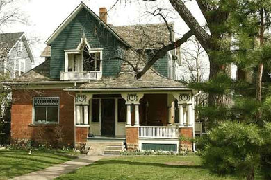 Large green two-story brick exterior home idea in Denver