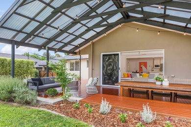 This is an example of a large modern backyard deck in Canberra - Queanbeyan with a pergola.