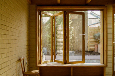 Diseño de salón abierto actual pequeño con paredes grises, suelo de madera en tonos medios, machihembrado y ladrillo
