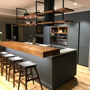 Idées déco pour une arrière-cuisine industrielle avec un électroménager en acier inoxydable et un îlot central.