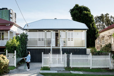 Inspiration for a mid-sized traditional one-storey white house exterior in Brisbane with wood siding, a hip roof and a metal roof.