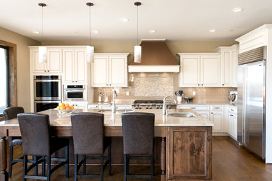 Elegant medium tone wood floor eat-in kitchen photo in Denver with an undermount sink, granite countertops, beige backsplash, ceramic backsplash, stainless steel appliances and an island