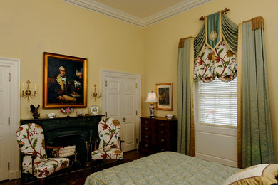 Bedroom - mid-sized traditional guest medium tone wood floor and brown floor bedroom idea in DC Metro with yellow walls, a stone fireplace and a standard fireplace