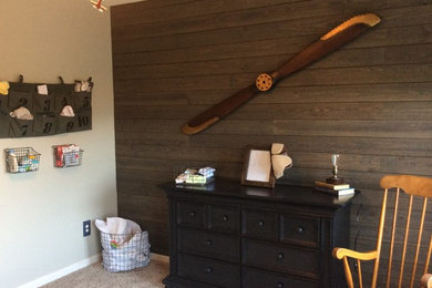 Mid-sized arts and crafts boy carpeted and beige floor nursery photo in Other with brown walls