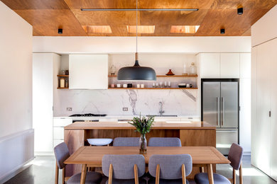 Design ideas for a medium sized contemporary galley open plan kitchen in Melbourne with a double-bowl sink, flat-panel cabinets, wood worktops, white splashback, porcelain splashback, stainless steel appliances, concrete flooring, an island, grey floors, white worktops and a timber clad ceiling.