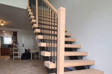 Example of a mid-sized trendy wooden floating mixed material railing staircase design in New York