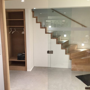 Eingangsbereich mit beleuchteter Treppe und Einbauschränken
