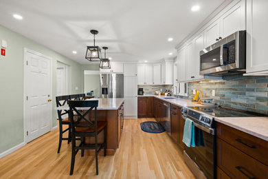 Eat-in kitchen - l-shaped light wood floor and brown floor eat-in kitchen idea in Boston with shaker cabinets, blue backsplash, stainless steel appliances and an island