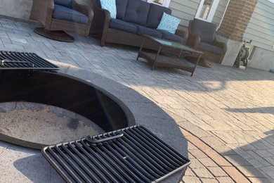 Inspiration for a contemporary backyard concrete paver patio remodel in New York with a fire pit