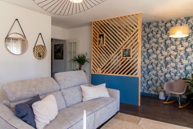 Aménagement d'un salon blanc et bois scandinave de taille moyenne et ouvert avec un mur bleu, un sol en bois brun, un téléviseur fixé au mur et du papier peint.