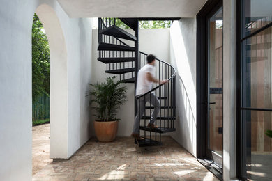 Example of a small minimalist brick floor and red floor entryway design in Austin with white walls and a glass front door