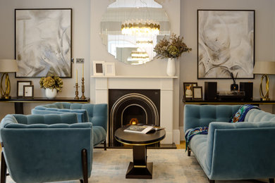 Inspiration for a contemporary formal and grey and teal enclosed living room in London with beige walls, light hardwood flooring, a standard fireplace, a stone fireplace surround, beige floors and a chimney breast.