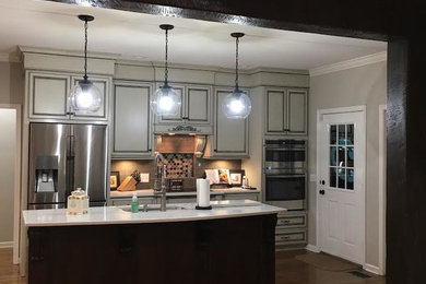 Inspiration for a mid-sized transitional single-wall dark wood floor and brown floor open concept kitchen remodel in Birmingham with an undermount sink, raised-panel cabinets, gray cabinets, gray backsplash, stainless steel appliances and an island