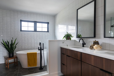 Trendy master white tile and porcelain tile ceramic tile, gray floor and double-sink bathroom photo in Chicago with flat-panel cabinets, brown cabinets, white walls, an undermount sink, quartz countertops, white countertops, a niche and a built-in vanity