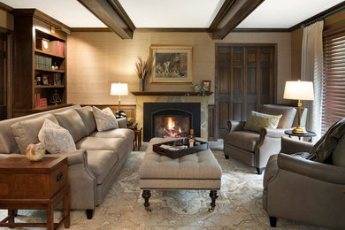 Inspiration for a mid-sized traditional enclosed living room in Minneapolis with a library, beige walls, limestone floors, a standard fireplace, a stone fireplace surround, a wall-mounted tv and multi-coloured floor.