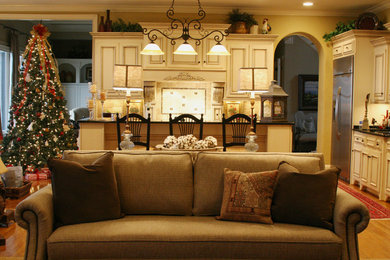 Mid-sized elegant open concept light wood floor and beige floor living room photo in Birmingham with yellow walls, a standard fireplace and a brick fireplace