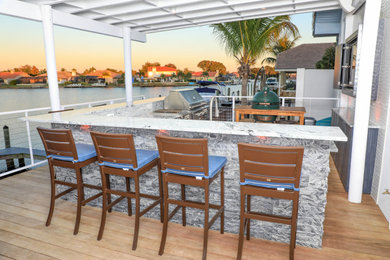 Huge backyard patio kitchen photo in Tampa