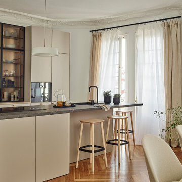 Una cocina abierta con isla, vitrina y comedor