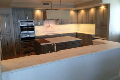 Mid-sized traditional l-shaped eat-in kitchen in Jacksonville with raised-panel cabinets, grey cabinets, marble benchtops, white splashback, subway tile splashback, stainless steel appliances, limestone floors and with island.